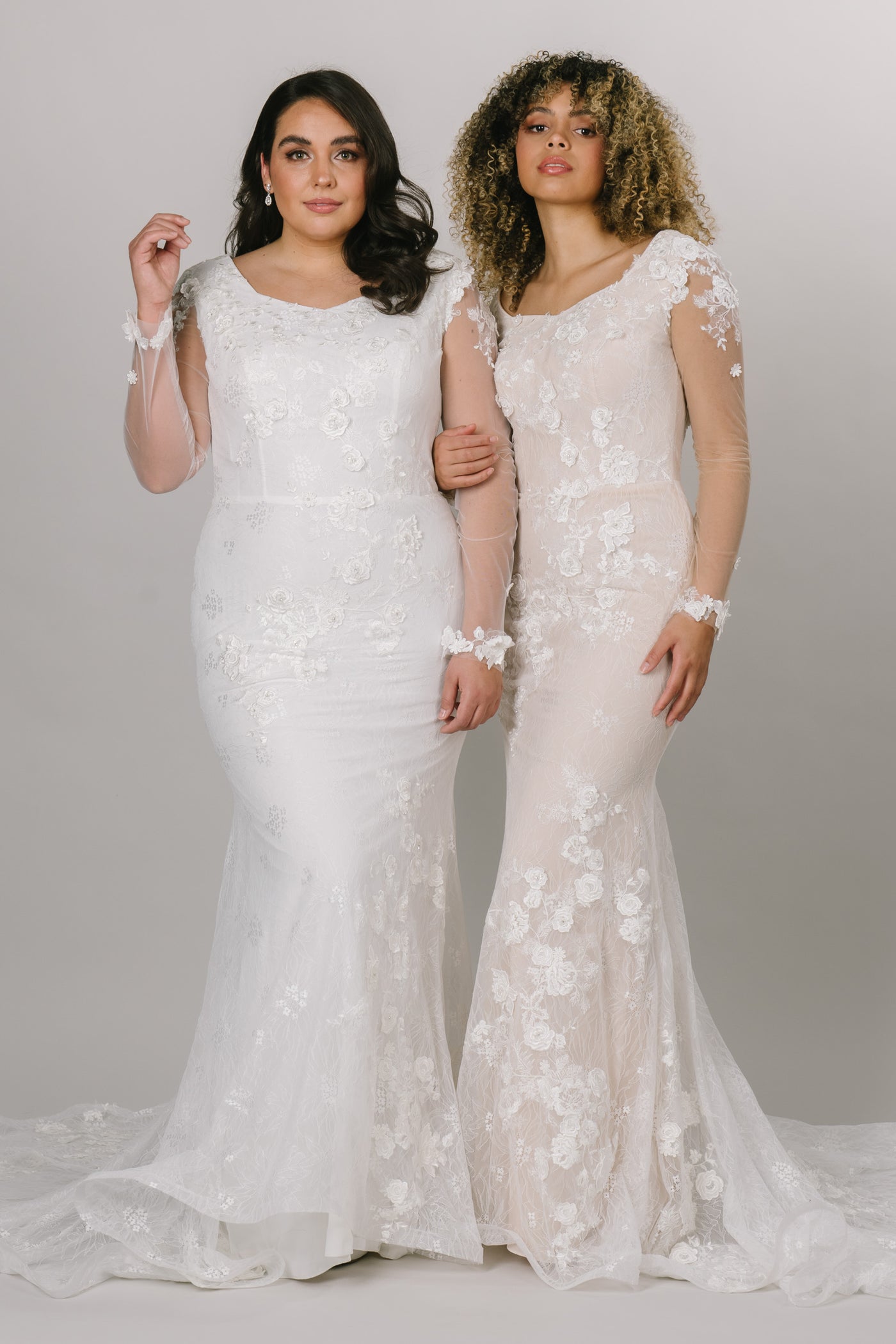 Two models showcasing the dress in white and nude. This modest wedding dress comes in many sides. 