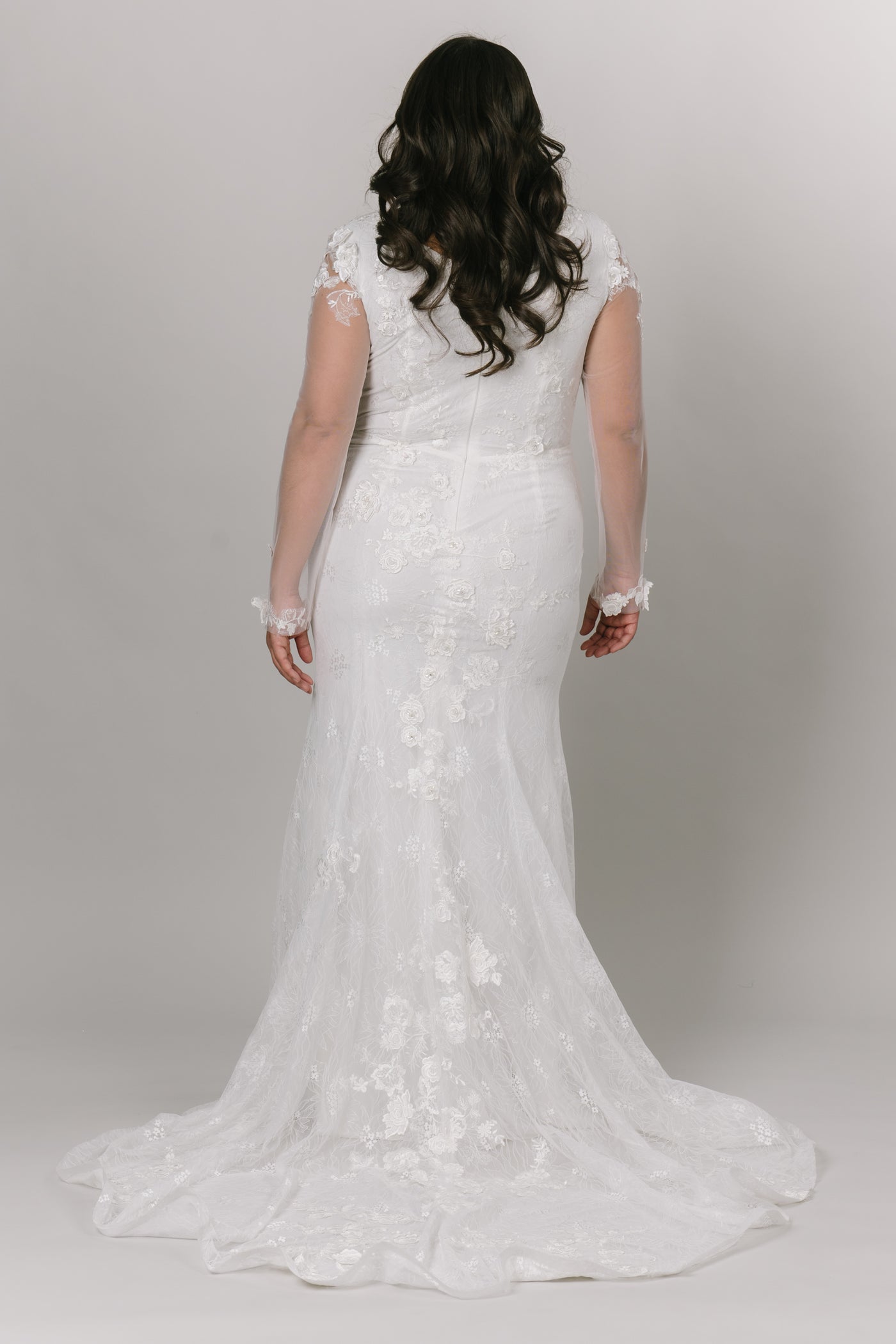 The back view of the wedding dress with a seamless zipper with illusions sleeves with a small train.