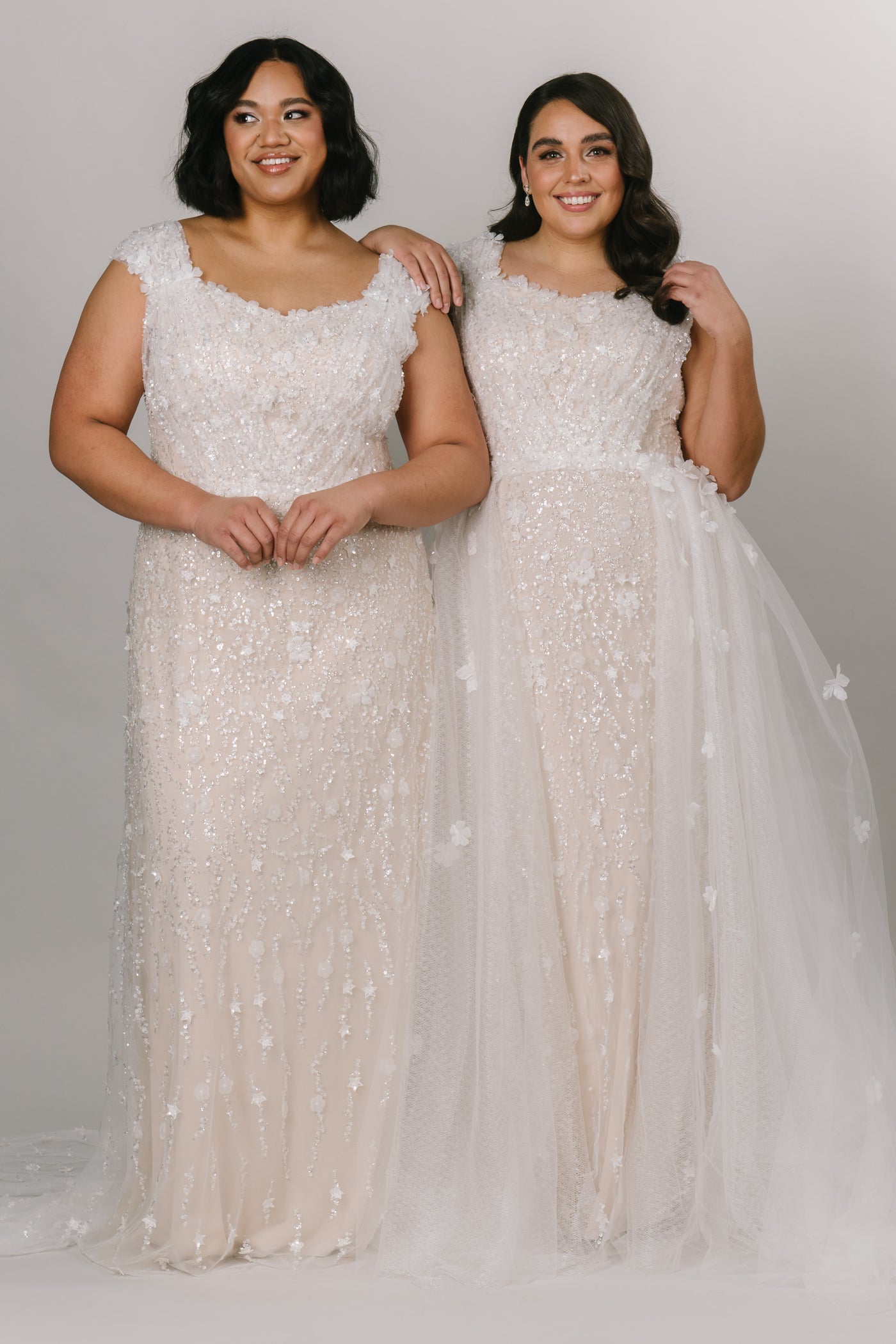 Two plus size models showcasing the dress on the left  is in size 18 and the model on the right has the overskirt and in a size 14.