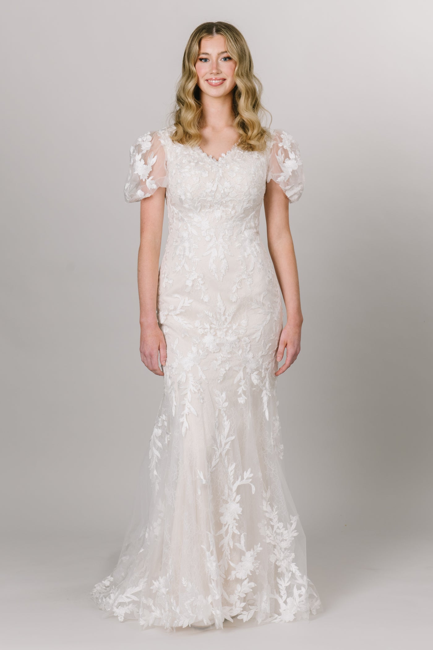 Moments Made Bridal gown with flutter sleeves and v-neckline. It is a fitted dress with a gorgeous long train. It is the perfect modest wedding dress for any season.