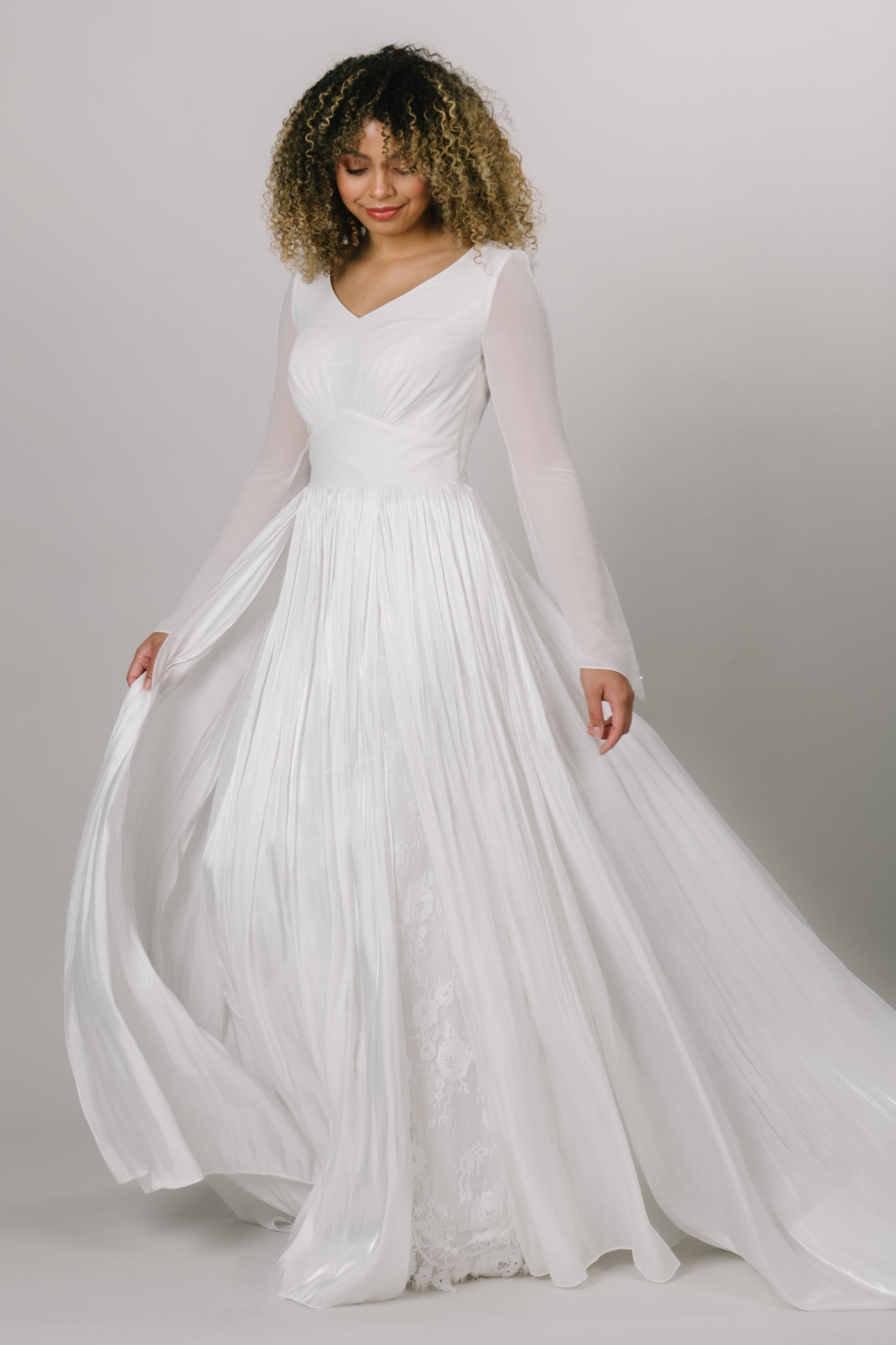 Elegant modest wedding dress with chiffon bell sleeves. This Moments Made Bridal dress has a v-neckline and aline fit. It has chiffon layers and is so flowy. This dress is perfect for twirling and enjoying your wedding day.