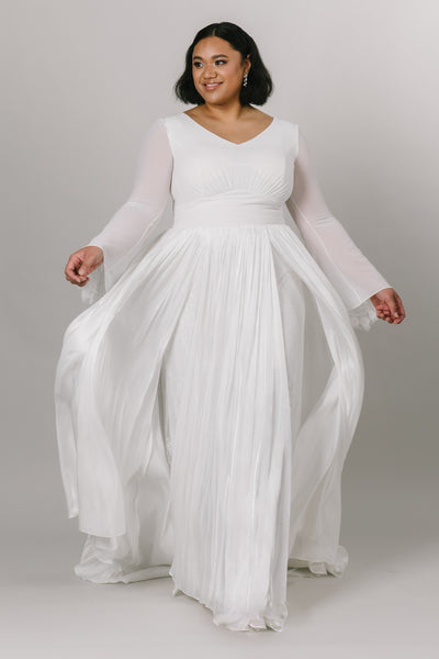 Elegant modest wedding dress with chiffon bell sleeves. This Moments Made Bridal dress has a v-neckline and aline fit. It has chiffon layers and is so flowy. This dress is perfect for twirling and enjoying your wedding day.