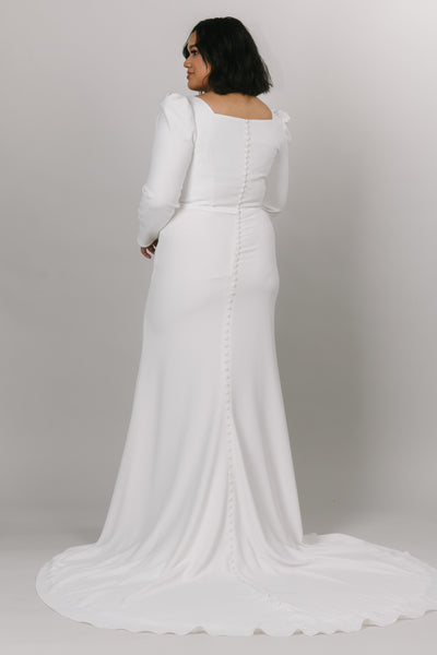 Plus size of modest wedding dress with long puffed sleeves. This dress is fitted with a knee high slit and a square neck line. 